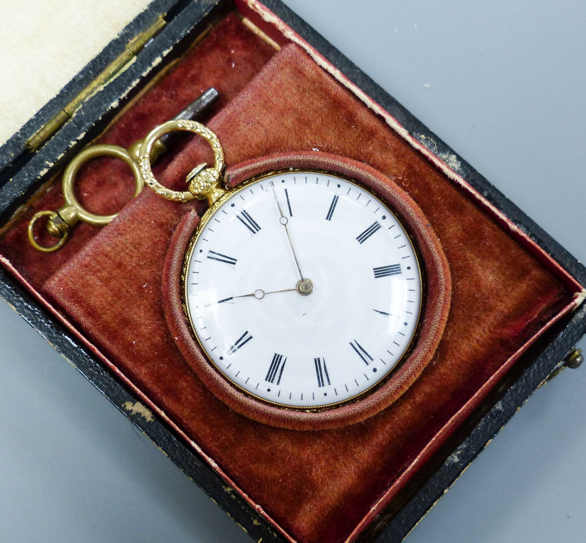 A cased 19th century continental engraved yellow metal open faced fob watch, case diameter 36mm, gross weight 26.6 grams, with watch key.